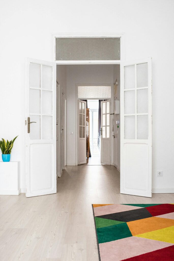 Spacious and colorful modern living room featuring open doors and vibrant decor.