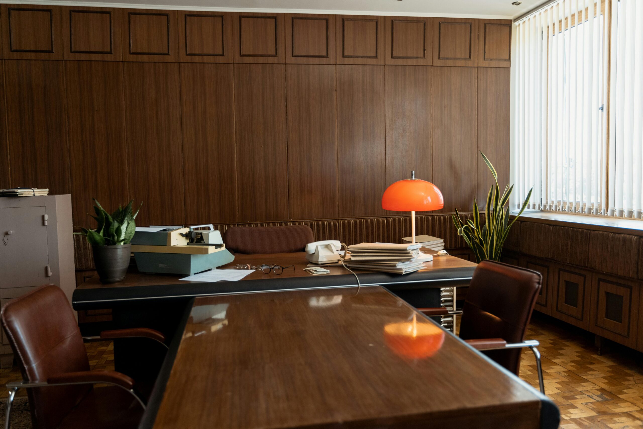 Vintage office setup featuring a typewriter, rotary phone, and retro furnishings.