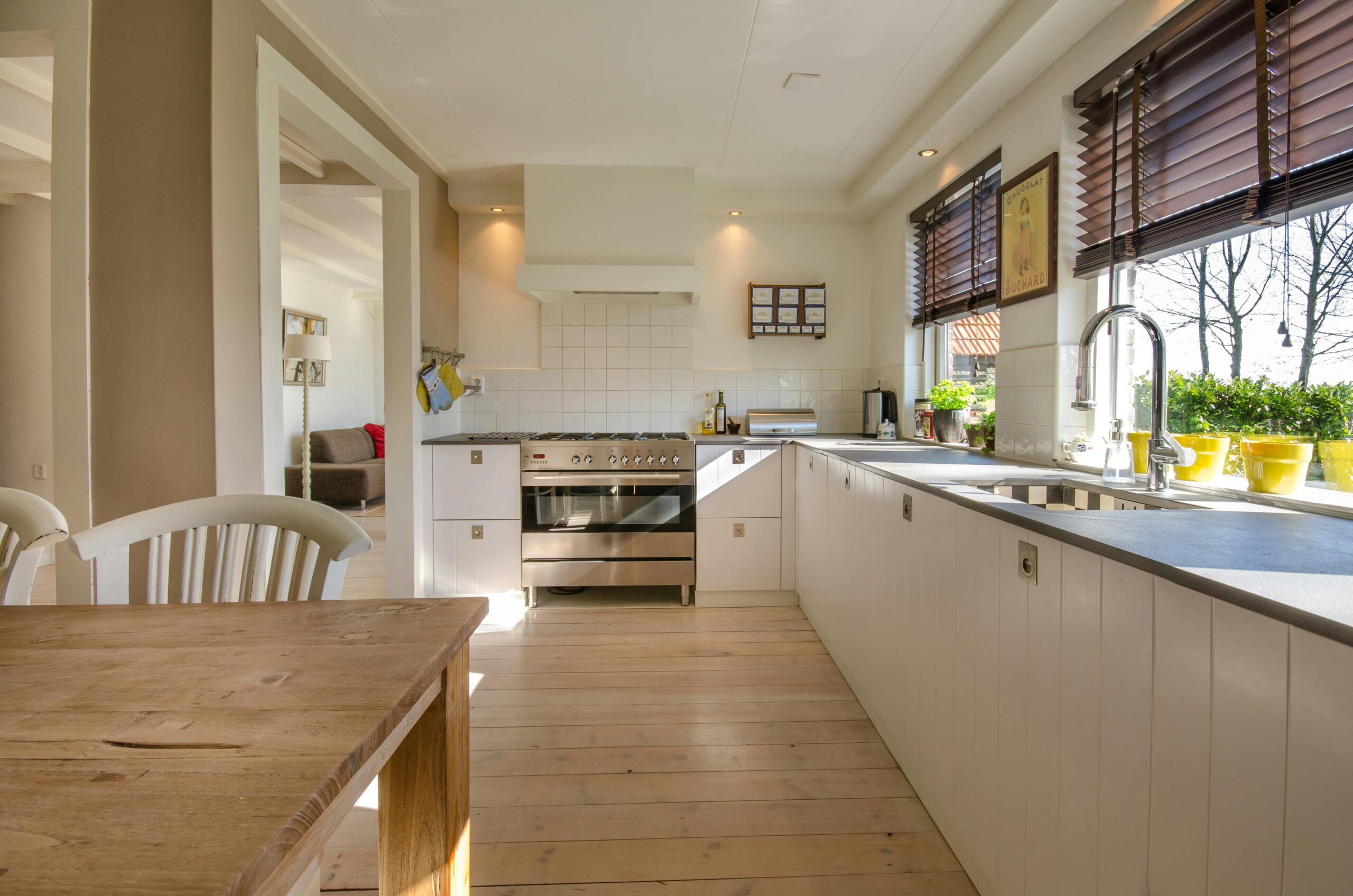Bright kitchen interior featuring wooden flooring, sleek cabinets, and natural sunlight.