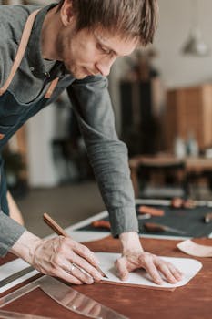 An artisan skillfully cutting leather with precision in a well-lit workshop, demonstrating craftsmanship.