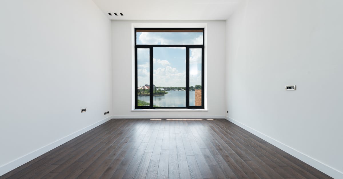 Interior of modern spacious light room with wooden laminate floor white walls and panoramic windows